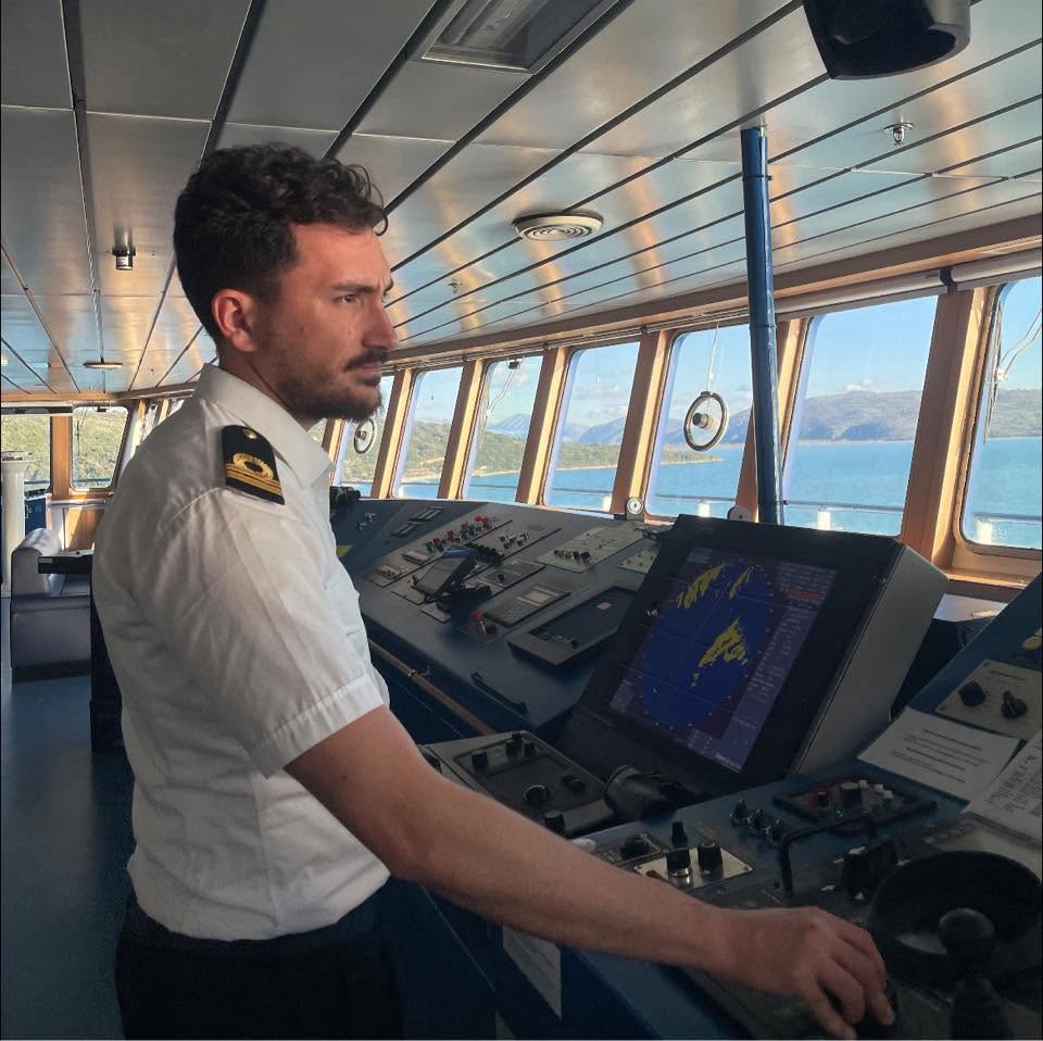 An officer in white uniform on the bridge of a ship
