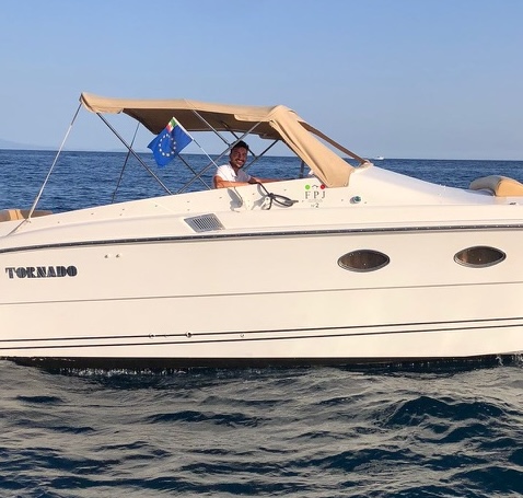 Giovanni at the helm of a Tornado motorboat at sea